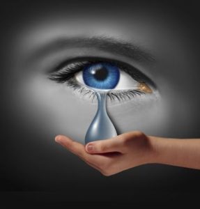 Hand catching tear from eye